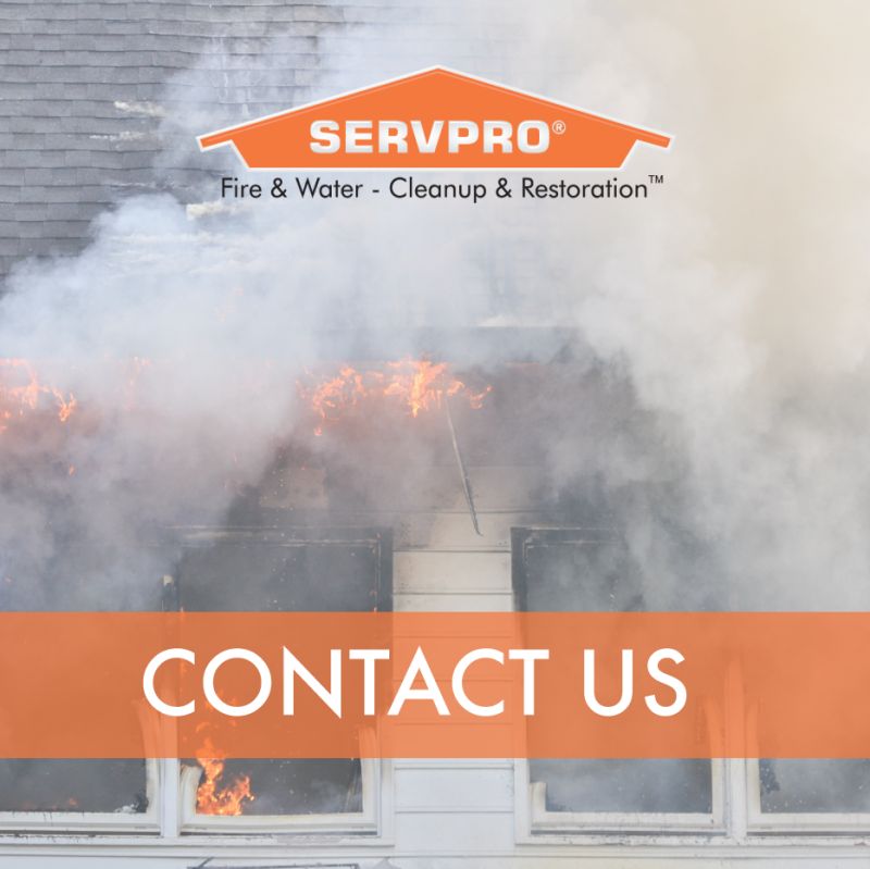 Smoke coming out of a building with the SERVPRO logo and "contact us" overtop of the image.